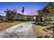 Charming single-story home with a cracked driveway and lush, mature landscaping at 2440 Ednor St, Port Charlotte, FL 33952