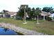 Backyard view with a waterfront, a well manicured lawn and tropical trees at 26287 Stillwater Cir, Punta Gorda, FL 33955