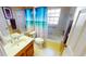 Well-lit bathroom featuring a shower with a themed curtain and ceramic tile flooring at 26287 Stillwater Cir, Punta Gorda, FL 33955