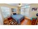 Cozy bedroom featuring wood floors, two windows, and a ceiling fan at 26287 Stillwater Cir, Punta Gorda, FL 33955