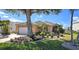 Charming single-story home with lush landscaping, mature tree, and a neutral exterior paint at 26287 Stillwater Cir, Punta Gorda, FL 33955
