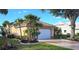 Charming single-story home with a two-car garage, well-manicured lawn, and lush landscaping featuring palm trees at 26287 Stillwater Cir, Punta Gorda, FL 33955