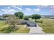 Well-manicured home with a large lawn, mature trees, and a paved driveway leading to an attached two-car garage at 31093 N Bend St, Punta Gorda, FL 33982