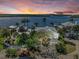 Breathtaking aerial view of waterfront property with lush landscaping, a private dock, and serene water views at sunset at 3790 Peace River Dr, Punta Gorda, FL 33983