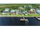 Aerial view of waterfront home with a private dock, lush landscaping, and swimming pool at 3790 Peace River Dr, Punta Gorda, FL 33983
