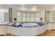 A luxurious bathroom with a large soaking tub, surrounded by bright windows and stylish cabinetry at 3790 Peace River Dr, Punta Gorda, FL 33983