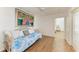 Bright bedroom showcasing light hardwood floors, ceiling fan, and a daybed with pillows at 3790 Peace River Dr, Punta Gorda, FL 33983
