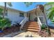 Inviting front entrance featuring brick steps, a charming porch, and lush tropical landscaping at 3790 Peace River Dr, Punta Gorda, FL 33983