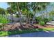 Beautifully landscaped front yard with mature palm trees, tropical foliage, and a well-maintained lawn at 3790 Peace River Dr, Punta Gorda, FL 33983