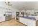 A spacious kitchen featuring white cabinetry, stainless steel appliances, and a large blue-tiled island at 3790 Peace River Dr, Punta Gorda, FL 33983