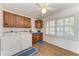 Well-lit laundry room features wood cabinets, a washer, dryer, and window with shutters at 3790 Peace River Dr, Punta Gorda, FL 33983