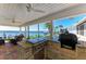 Waterfront outdoor kitchen with a built-in grill, granite countertops, ceiling fans, and water views at 3790 Peace River Dr, Punta Gorda, FL 33983