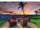 Relaxing outdoor seating area with stylish chairs, a cozy fire pit, and breathtaking waterfront views at sunset at 3790 Peace River Dr, Punta Gorda, FL 33983