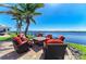Outdoor patio area with comfortable seating around a fire pit, with a waterfront view and palm trees at 3790 Peace River Dr, Punta Gorda, FL 33983