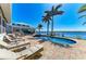 An expansive backyard pool and spa, featuring lounge chairs, a dock, and views of the waterfront at 3790 Peace River Dr, Punta Gorda, FL 33983