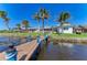 Waterfront home with a private dock, lush landscaping, and a screened lanai at 3790 Peace River Dr, Punta Gorda, FL 33983