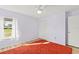 This room features a large red rug, a ceiling fan, and a bright window at 3940 Abbotsford St, North Port, FL 34287
