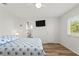 This bedroom includes a ceiling fan, a window, a mounted TV and ensuite bath at 3940 Abbotsford St, North Port, FL 34287