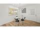 This dining room includes modern lighting, a glass table, and unique black and white chairs at 3940 Abbotsford St, North Port, FL 34287