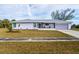 Charming single-story home with a well-maintained lawn, purple paint, and a cozy screened porch at 3940 Abbotsford St, North Port, FL 34287
