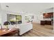 Open-concept living area with wood floors, sleek furniture, and view to the outdoors at 3940 Abbotsford St, North Port, FL 34287