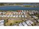 Aerial view of a neighborhood featuring tidy streets, modern homes with metal roofs, and proximity to a scenic lake at 42210 Lake Timber Dr, Punta Gorda, FL 33982