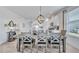 Bright dining room featuring a stylish chandelier and seating for six at 42210 Lake Timber Dr, Punta Gorda, FL 33982