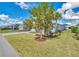 Beautiful front yard with mature trees, lush landscaping, and a well-maintained lawn, enhancing curb appeal at 42210 Lake Timber Dr, Punta Gorda, FL 33982