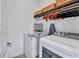 Bright laundry room featuring a modern washer and dryer, storage shelves, and an ironing board for convenience at 42210 Lake Timber Dr, Punta Gorda, FL 33982