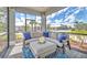 Inviting screened porch with comfortable seating, an area rug, and views of the surrounding landscape at 42210 Lake Timber Dr, Punta Gorda, FL 33982