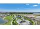 An aerial view of community entrance with golf course, lush landscaping, and a glimpse of the lake at 42239 Lake Timber Dr, Punta Gorda, FL 33982