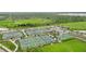 Aerial view of tennis and basketball courts with green surroundings and parking area at 42239 Lake Timber Dr, Punta Gorda, FL 33982