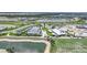 Aerial view of a golf course and clubhouse area, featuring a lake and golf carts, surrounded by lush landscaping at 42239 Lake Timber Dr, Punta Gorda, FL 33982