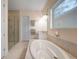Bright bathroom showcasing an enclosed glass shower, soaking tub, and granite countertop at 42239 Lake Timber Dr, Punta Gorda, FL 33982