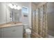 Bright bathroom features a white vanity, beige countertop, and shower with a patterned curtain at 42239 Lake Timber Dr, Punta Gorda, FL 33982