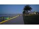 Scenic boardwalk at dusk overlooking the lake, with palm trees and a restaurant in the background at 42239 Lake Timber Dr, Punta Gorda, FL 33982