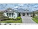 Charming home featuring beautiful landscaping, a metal roof, and a welcoming front porch at 42239 Lake Timber Dr, Punta Gorda, FL 33982