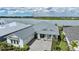 Stunning home with a lake view, lush landscaping, and a stylish gray metal roof at 42239 Lake Timber Dr, Punta Gorda, FL 33982