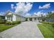 Inviting single-Gathering home with landscaped lawn and a gray brick driveway leading to the attached garage at 42239 Lake Timber Dr, Punta Gorda, FL 33982