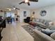 Open living room features tile flooring, ceiling fans, comfortable seating, and access to the dining area at 447 Yeager St, Port Charlotte, FL 33954