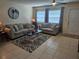 Comfortable living room with tile floors, neutral paint, ceiling fan, and lots of seating options at 447 Yeager St, Port Charlotte, FL 33954