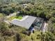 Aerial view of home featuring screened in pool with gray roof, lush landscaping, and tropical foliage at 4529 Enid Ln, North Port, FL 34288