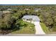 An aerial view of the property shows mature landscaping and a screened-in pool at 4529 Enid Ln, North Port, FL 34288