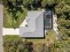 An aerial view of the home features a screened-in pool, a driveway, a well-kept lawn, and lush surrounding trees at 4529 Enid Ln, North Port, FL 34288