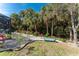 Private backyard with lush landscaping, featuring palm trees, tropical plants, a bench and a screened lanai at 4529 Enid Ln, North Port, FL 34288