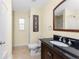 Bathroom featuring a dark wood vanity, granite counter, white tile shower, and an enclosed toilet at 4529 Enid Ln, North Port, FL 34288