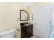 Bathroom featuring a dark wood vanity, granite counter, toilet, and tile shower with white accents at 4529 Enid Ln, North Port, FL 34288