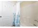 Bright bathroom with a white floral shower curtain and tiled walls at 4529 Enid Ln, North Port, FL 34288