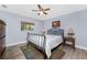 Bedroom with wood-look floors, neutral walls, ceiling fan, a queen-size bed, and bright natural light at 4529 Enid Ln, North Port, FL 34288