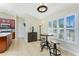 Dining area features tiled flooring, plantation shutters, a table with chairs, and flows into the kitchen space at 4529 Enid Ln, North Port, FL 34288